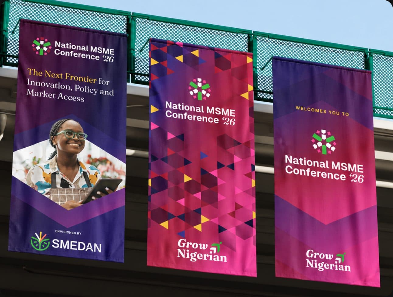 Three National MSME Conference ’26 flag banners hanging from a building