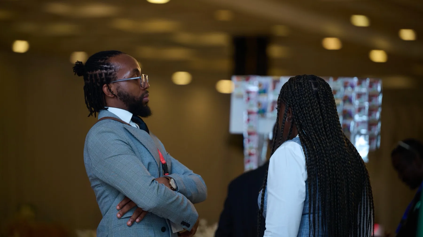 David ’Tobi Oyawoye on the conference floor, arms folded, in conversation
