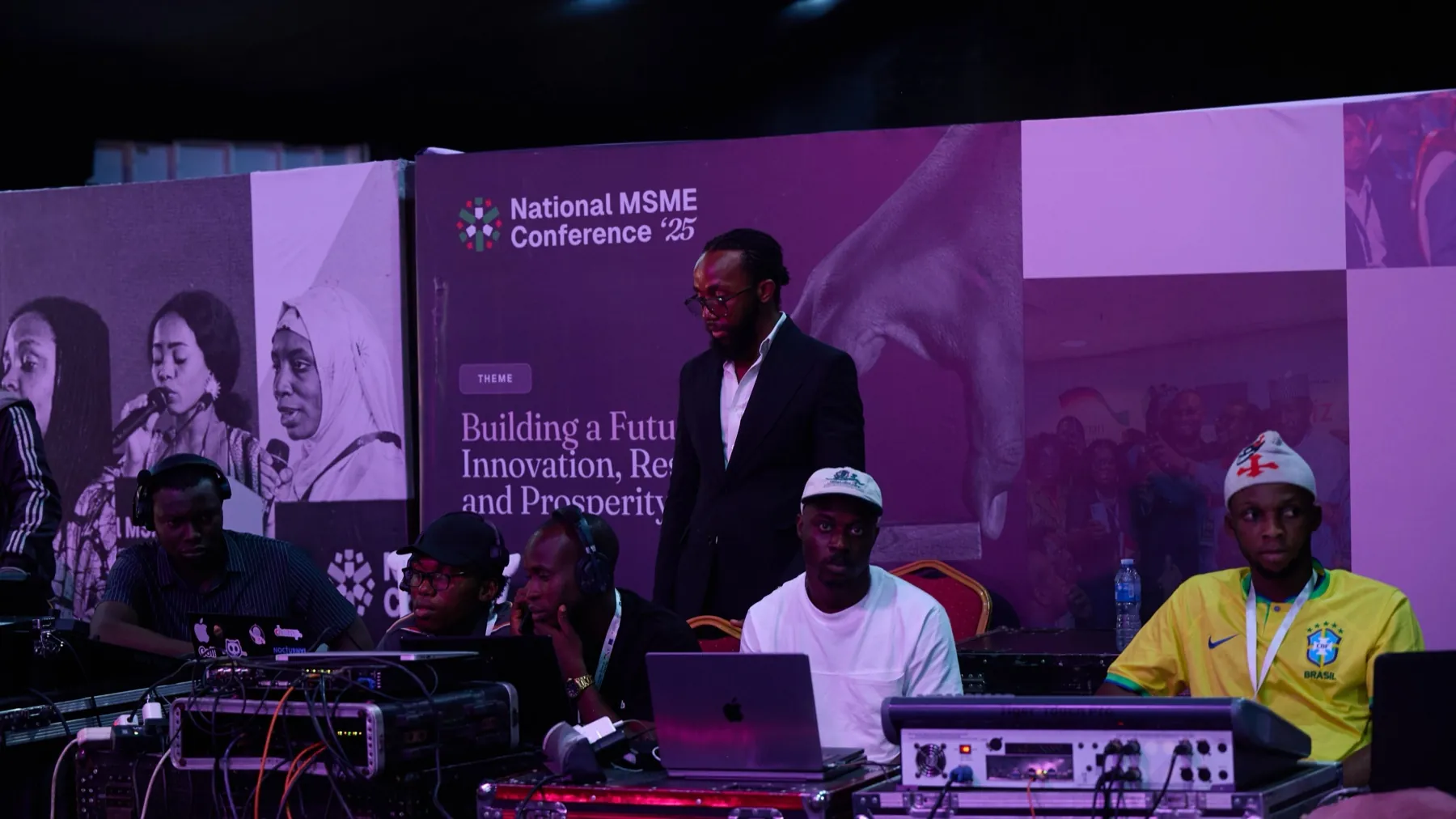 David ’Tobi Oyawoye standing at the control desk in front of the National MSME Conference ’25 backdrop
