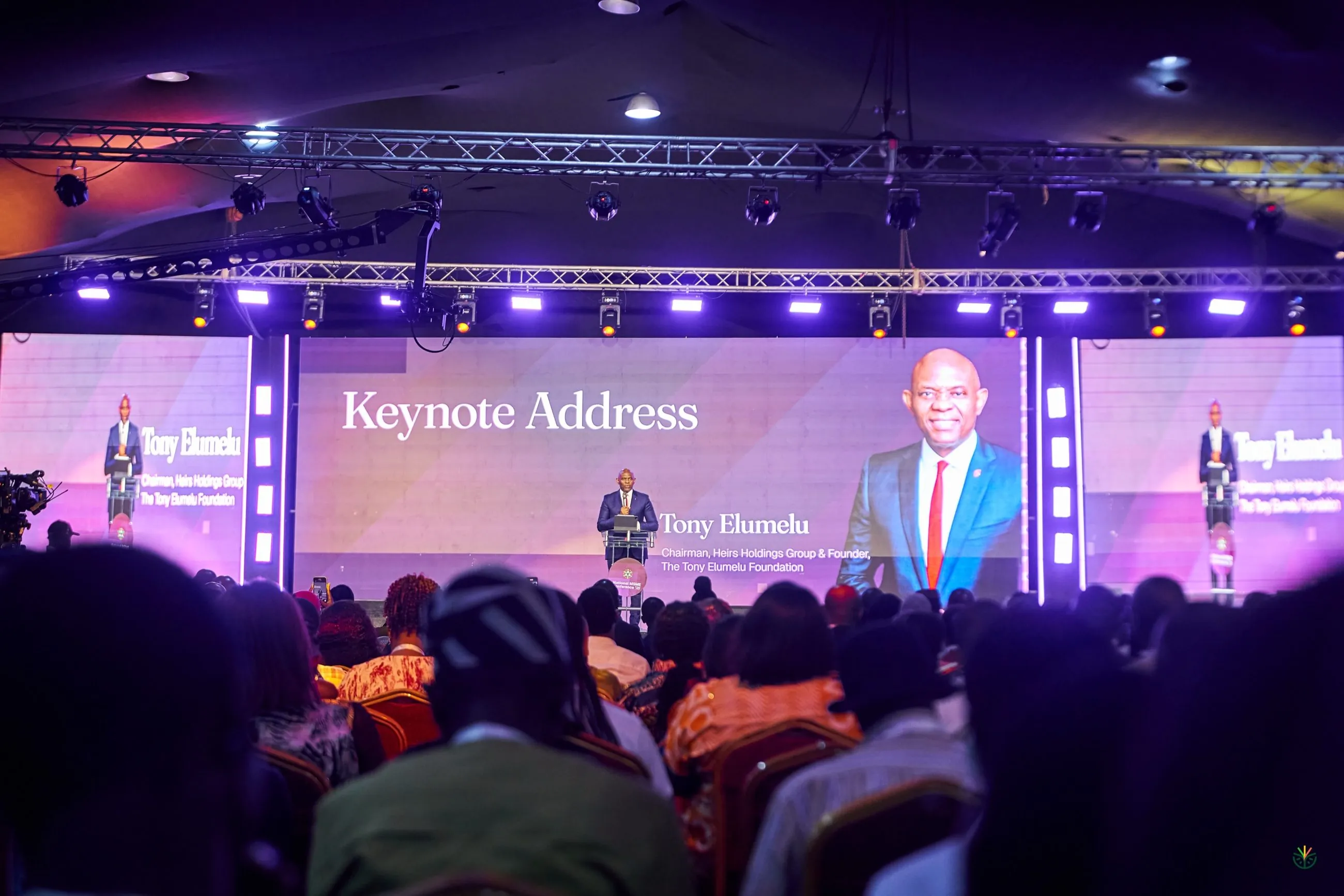 Tony Elumelu delivering the keynote address under purple stage light