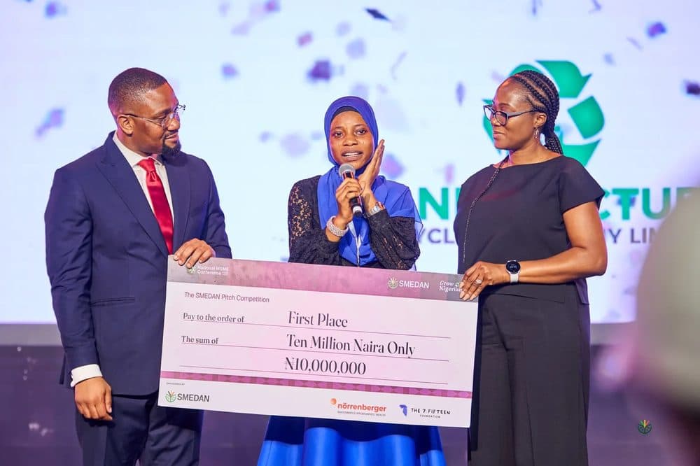 The 2025 pitch winner holding a ten million naira cheque on stage