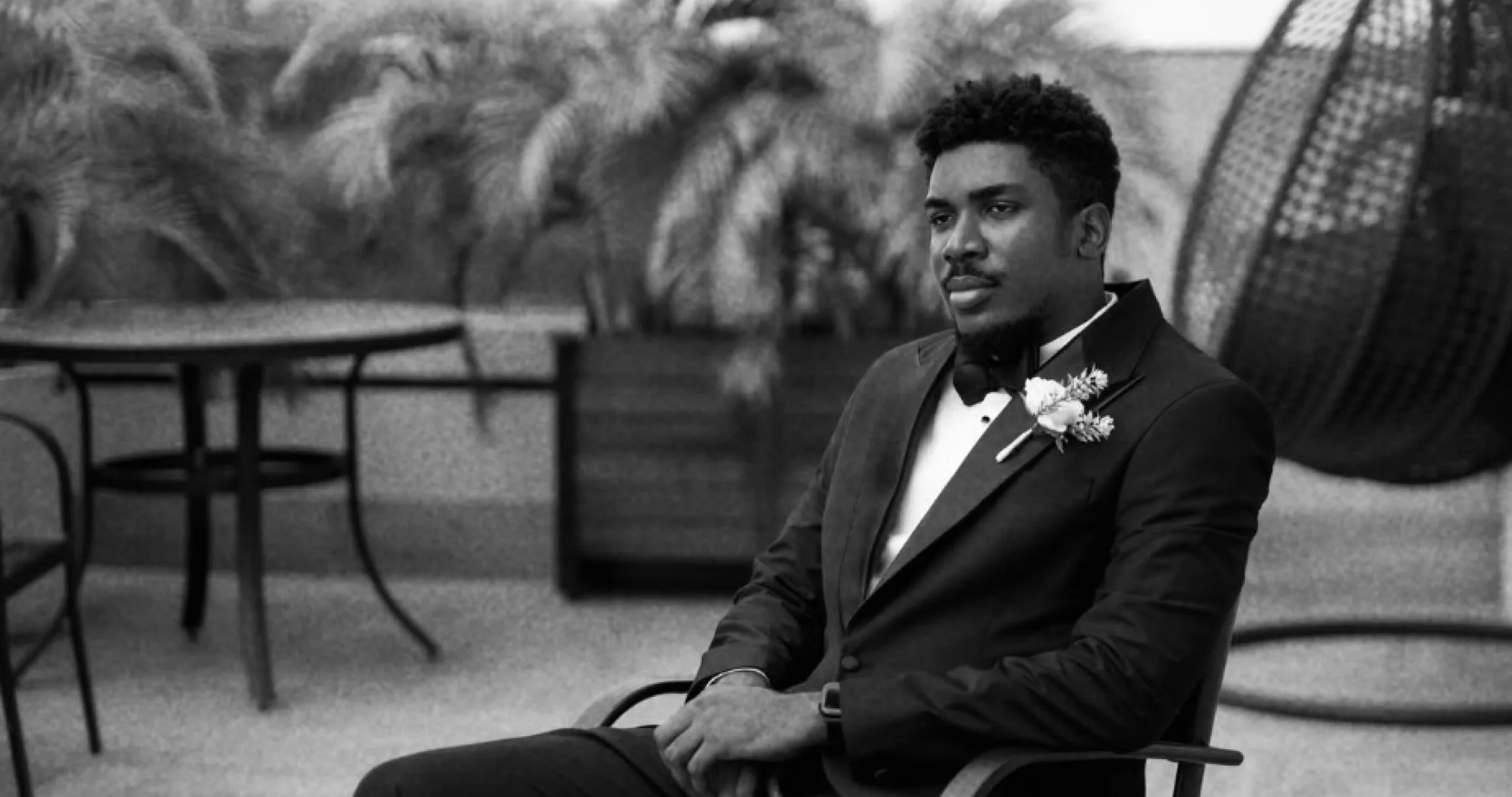 A groom in black and white, adjusting his cuff before the ceremony